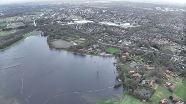 Das Luftbild zeigt eine überflutete Grasfläche. Im Hintergrund liegt die Stadt Oldenburg.